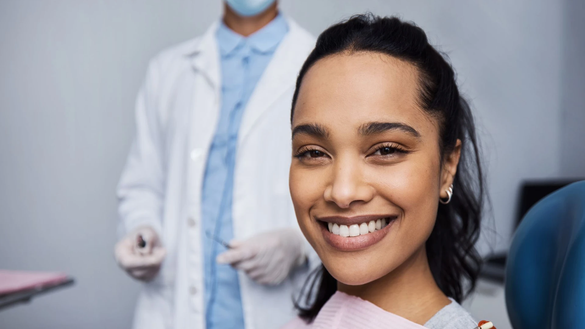 Imagen de una mujer muy sonriente en su visita al dentista mientras muestra sus dientes blancos, bien cuidados y sus encías rosas